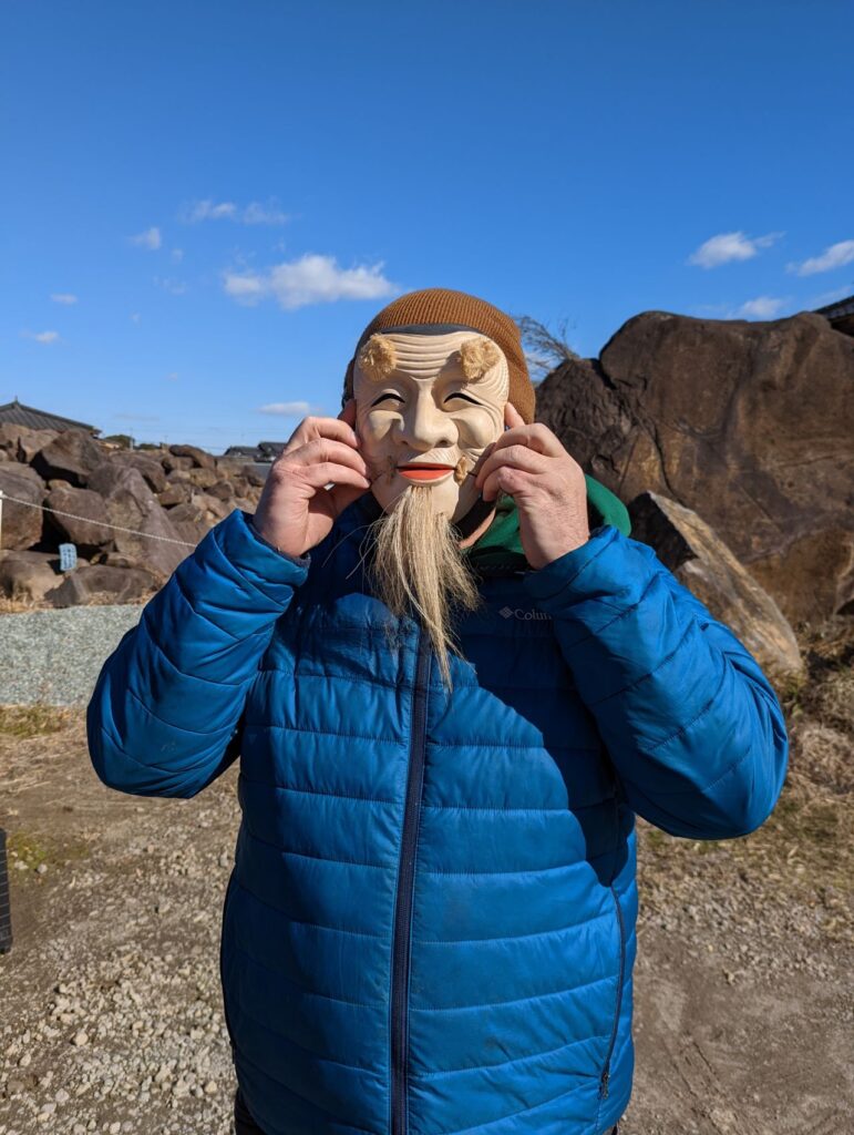 Eric Guizzetti from GTEC3D wearing a traditional Japanese handmade wooden mask at the historic Todoroki Suigen spring in Kumamoto, Japan.
